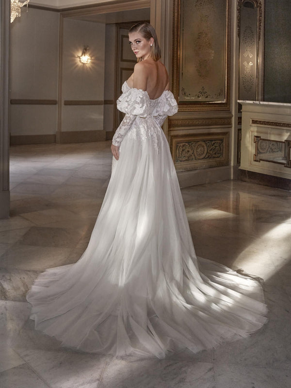Woman wearing a white lace wedding dress by Pronovias HYAM  in an elegant room.