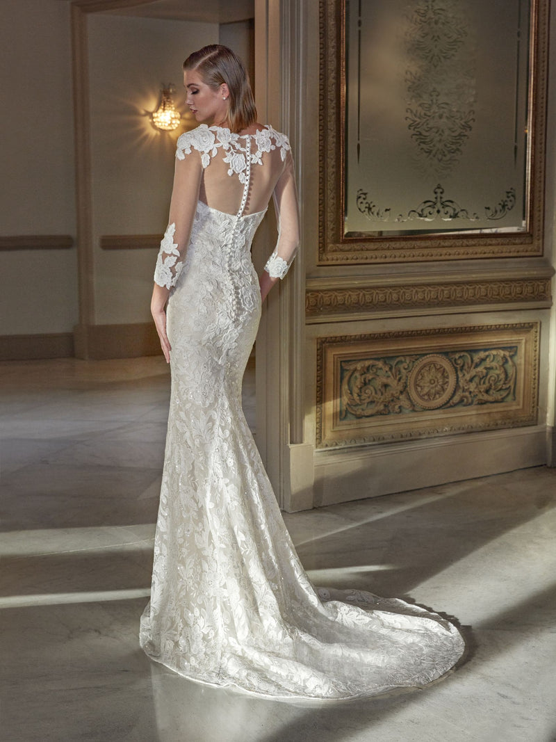 Woman wearing a white lace wedding dress by Pronovias HYAM  in an elegant room.
