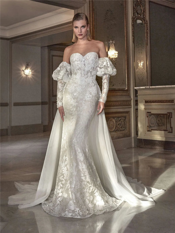Woman wearing a white lace wedding dress by Pronovias HYAM  in an elegant room.