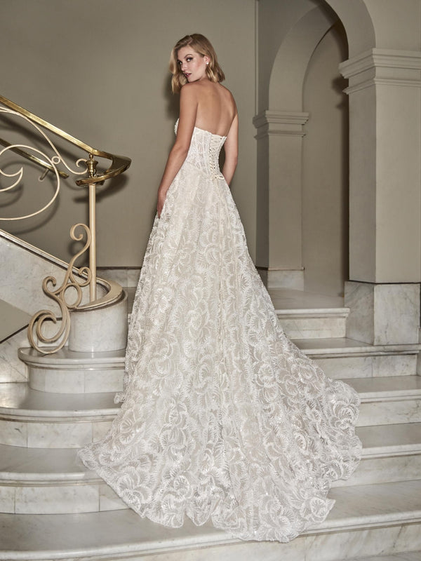 Woman in a white lace wedding dress  by Pronovias STARLEE standing on a staircase