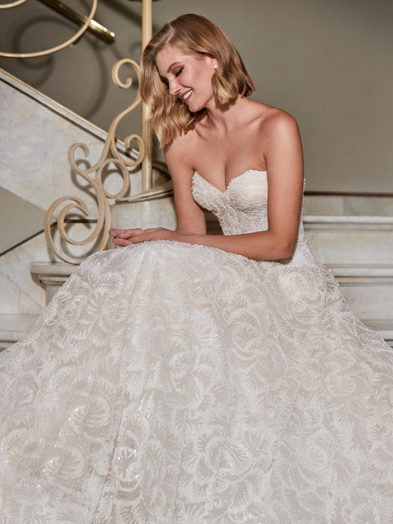Woman in a white wedding dress sitting on a staircase